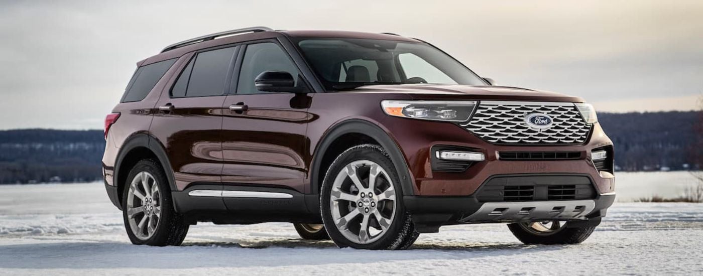A maroon 2020 Ford Explorer is parked on a snowy field.