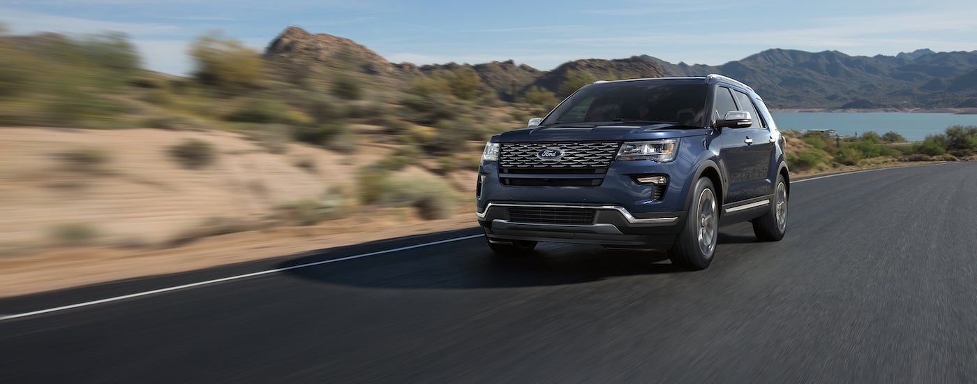 Blue 2018 Ford Explorer driving down an open road.