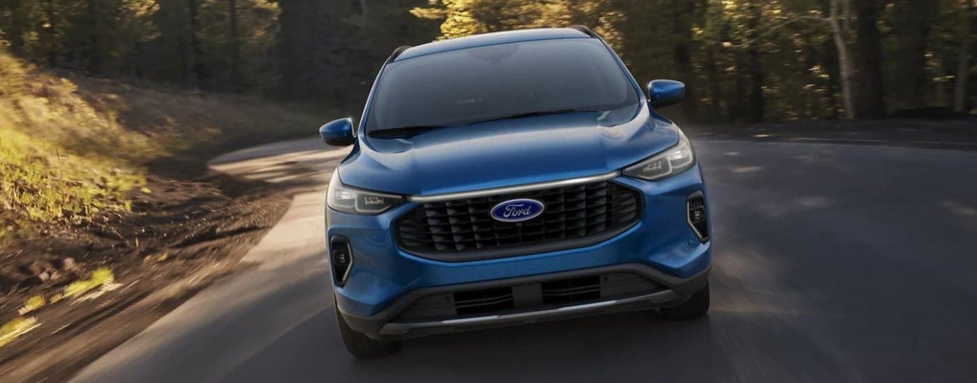 A blue 2023 Ford Escape driving down a road
