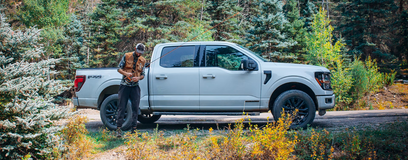 White 2025 Ford F-150 Lariat with a person holding their fishing rod