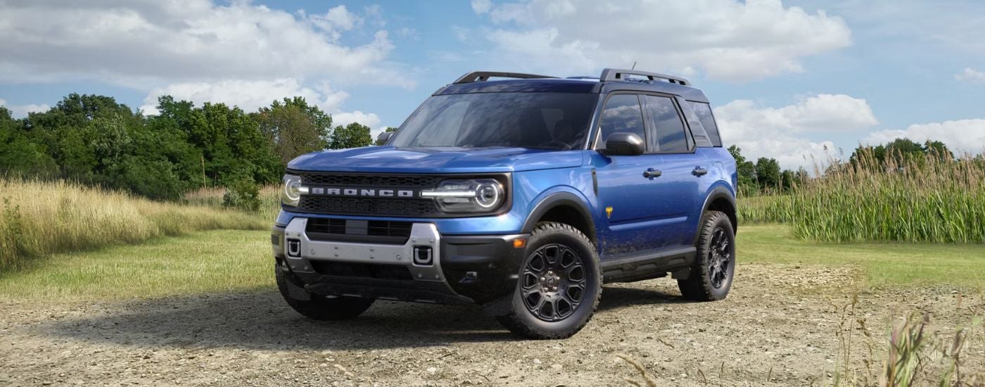 Blue 2026 Ford Bronco Sport parked near a field.