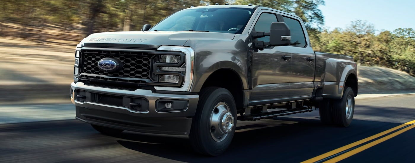 Grey 2026 Ford F-350 Super Duty driving down a road.