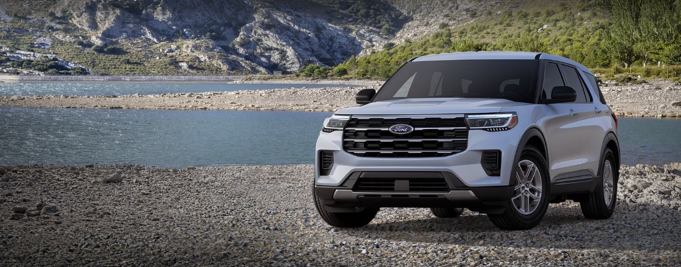 Silver 2026 Ford Explorer Active 100A parked on a rocky beach.