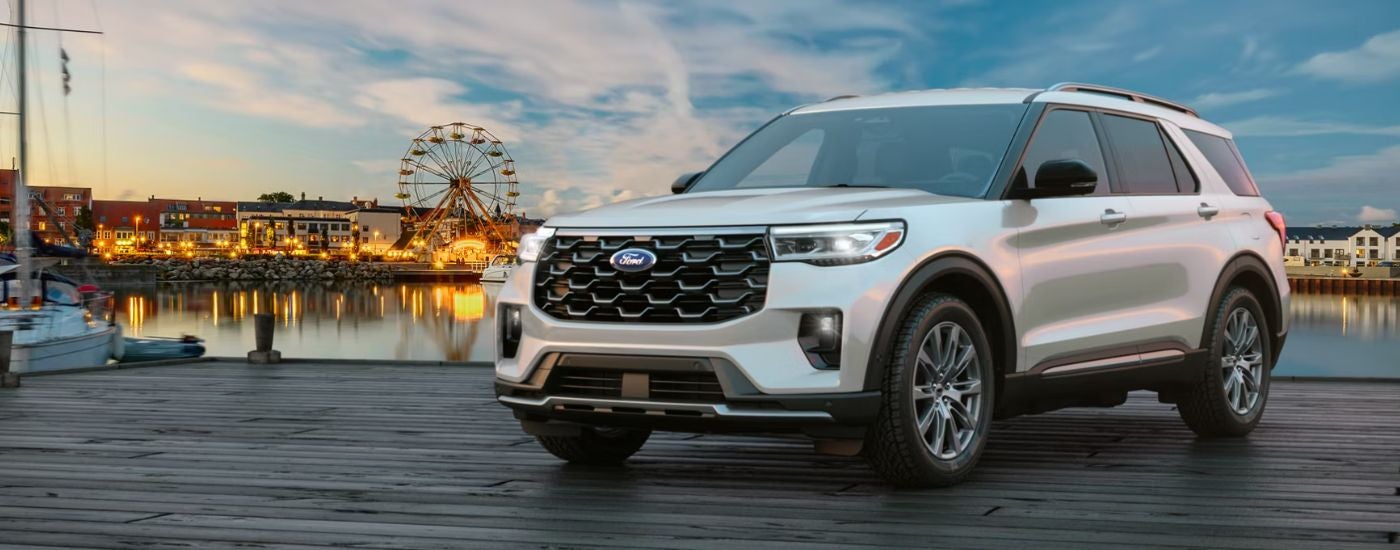 Silver 2026 Ford Explorer parked near an amusement park.