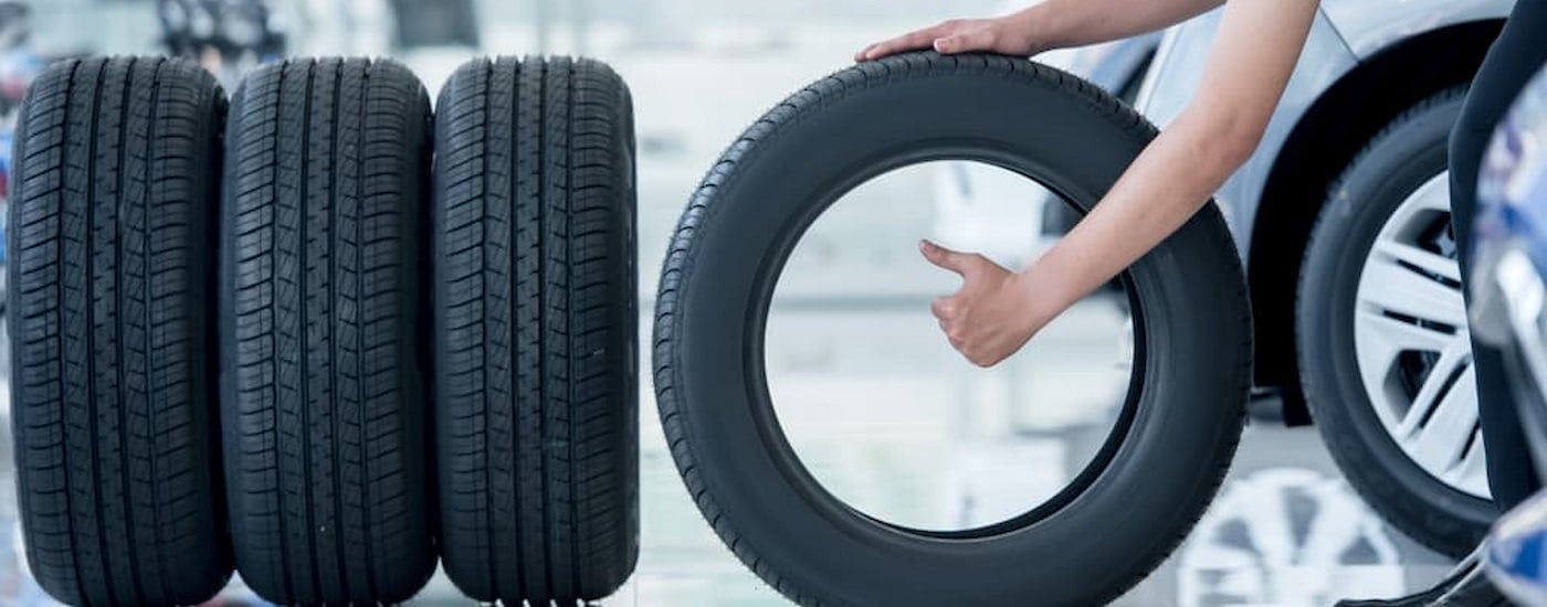 Person rolling a tire from a row.