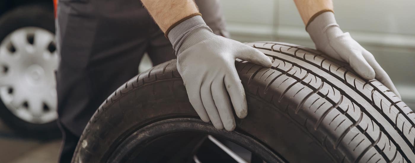 Close-up on the top of a tire being rolled by a mechanic.